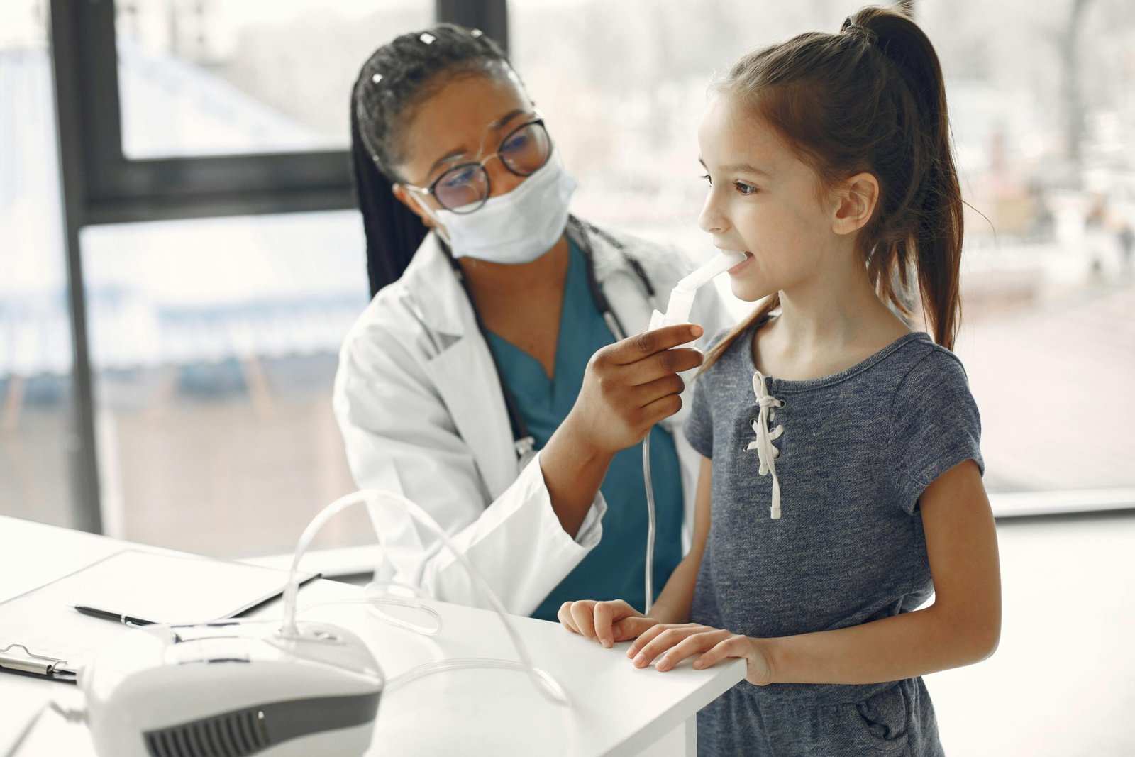 A female doctor examines a young girl in a medical office.