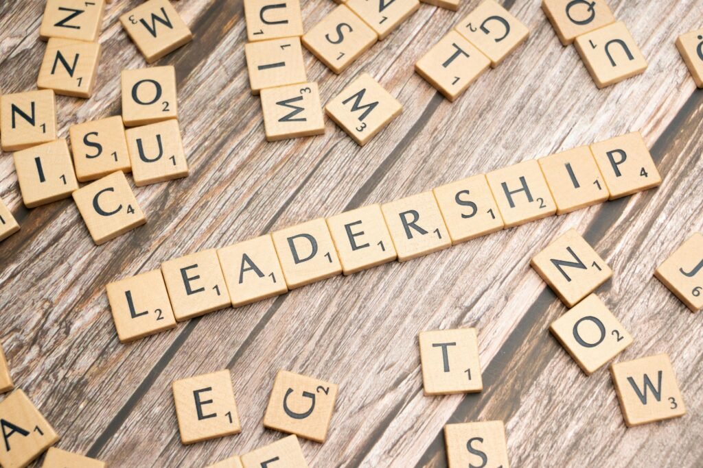 Wooden letter tiles spelling 'LEADERSHIP' on a wooden surface, symbolizing leadership qualities and skills.